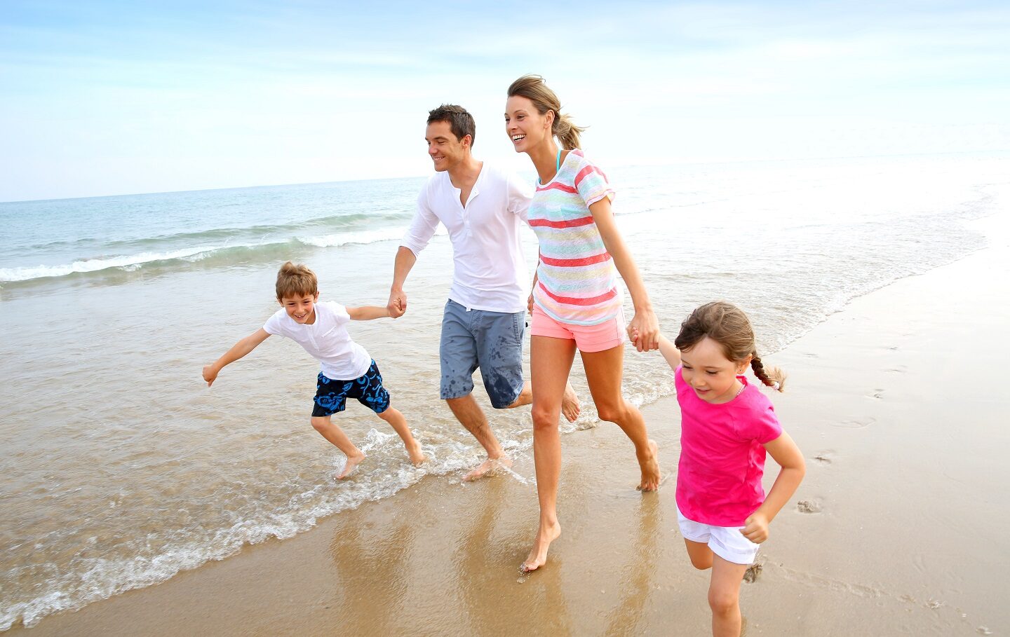 Happy family running on the beach