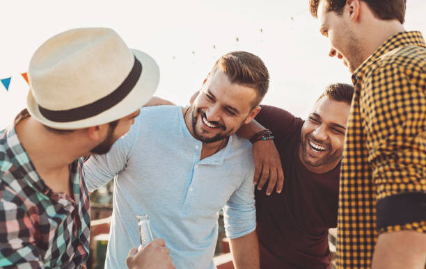 Group of young men drinking beer and chatting on a party